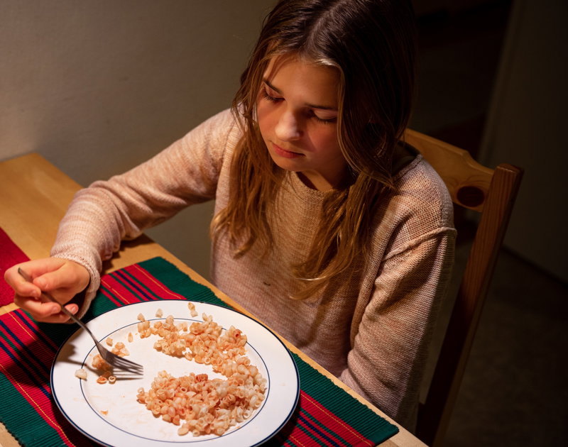 flicka äter makaroner på julafton